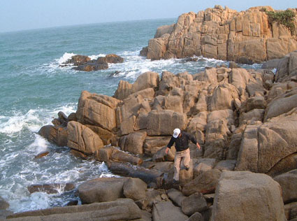 Lao Chao walking across rocks