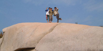 Boys posing on top of large rock