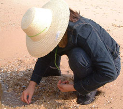 A lady, head down, sifting for pebbles
